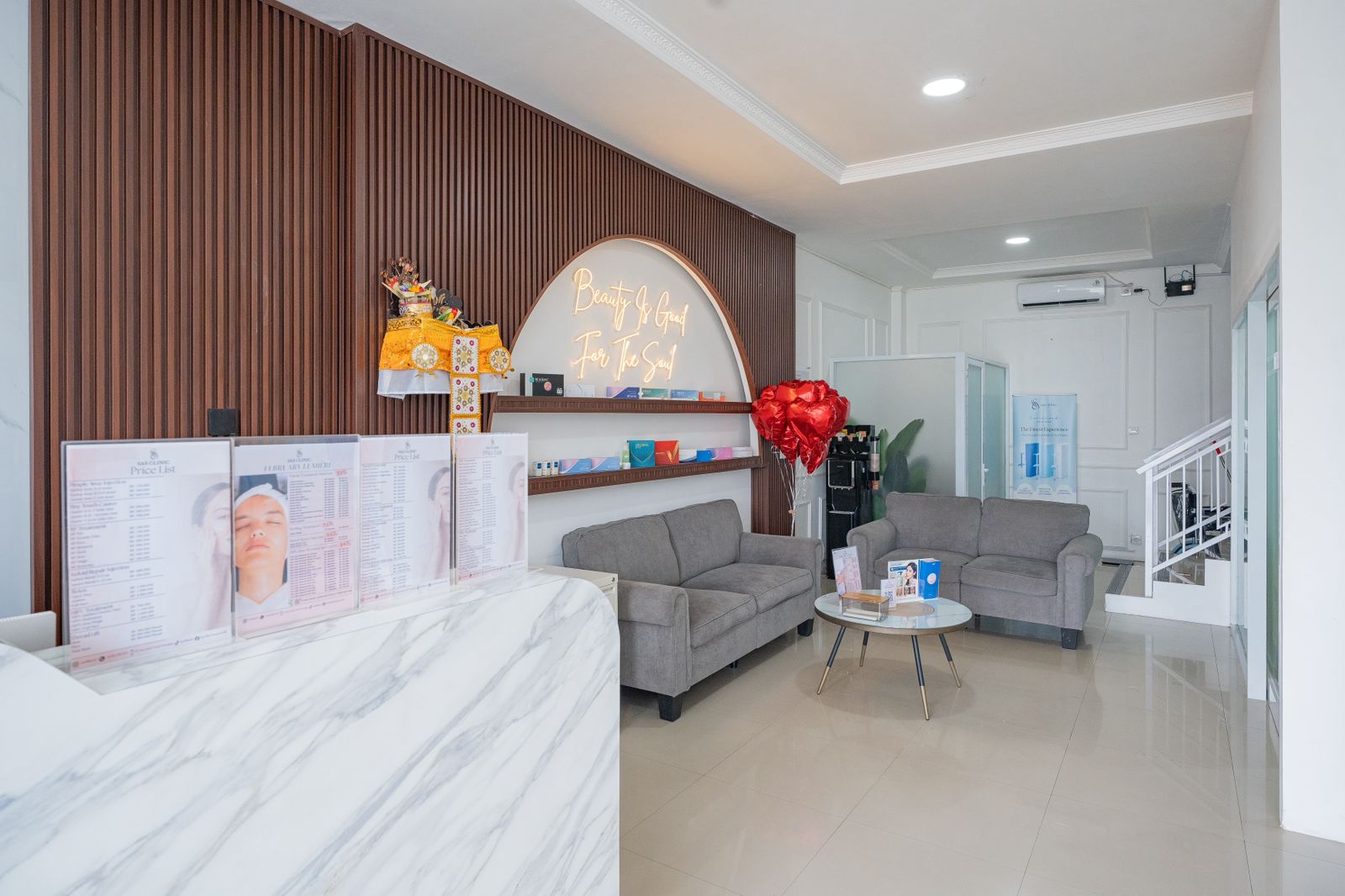 Lobby dan resepsionis SAS Clinic Denpasar dengan meja marmer dan neon sign Beauty Is Good For The Soul